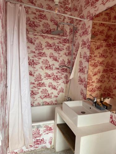 a bathroom with a white sink and pink wallpaper at Rachana Guest House in Mestre