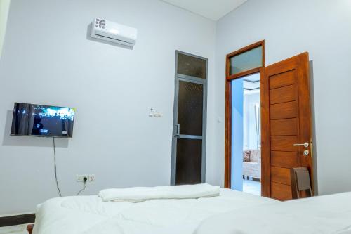 a bedroom with two beds and a television on the wall at Cozycore Airnbn in Dodoma