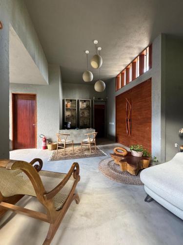 a living room with a couch and a table at Pousada Oribá Chalé Boutique Milagres - AL in São Miguel dos Milagres