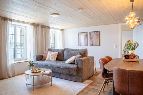 a living room with a couch and a table at Casa Lago in Tüscherz-Alfermée