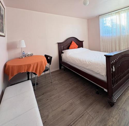 a small bedroom with a bed and a table at Bright Private Room near Montreal Fast WiFi in Brossard