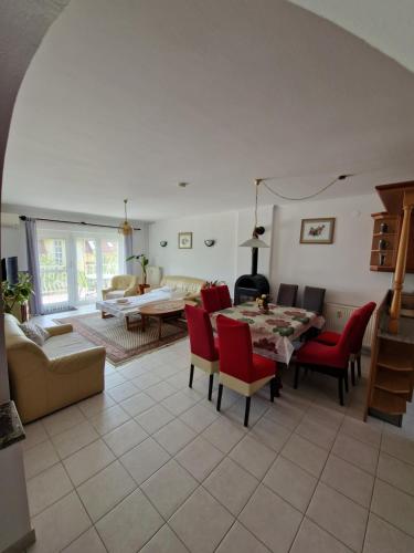 a living room with a table and red chairs at Landhaus Forrás in Balatonfüred