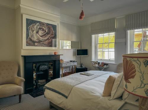a bedroom with a bed and a fireplace and a chair at The Laindons in Hastings