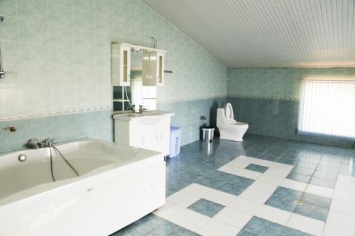 a large bathroom with a tub and a toilet at Premier Villas in Mardakan