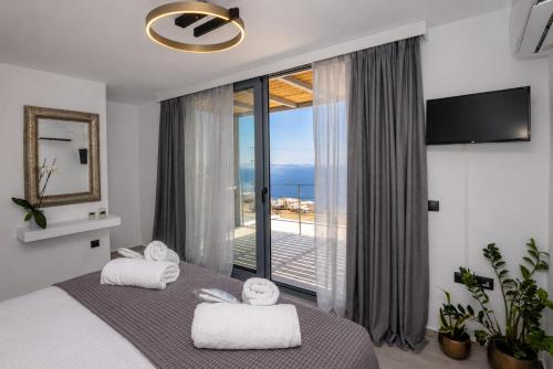 a bedroom with a bed with a view of the ocean at Tinian Sunset Villa in Istérnia