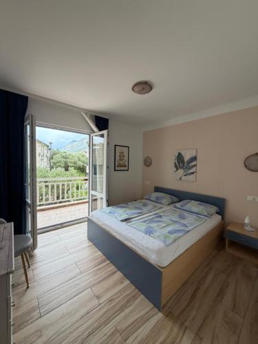 a bedroom with a large bed and a balcony at Apartments Lončar in Gradac