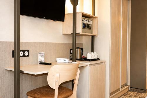 a small kitchen with a table and a chair at Hôtel La Solitude in Lourdes