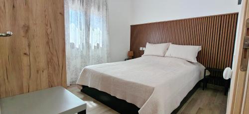 a bedroom with a large bed with a wooden headboard at Antoni's House Makri in Alexandroupoli