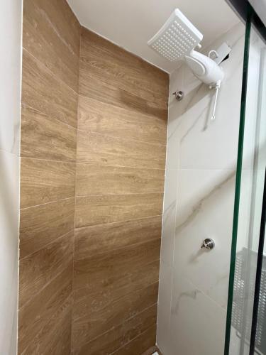a shower with a glass door in a bathroom at Casa da Dinda 105 in Rio das Ostras