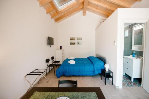 a bedroom with a blue bed and a table at Malicodia in Santa Maria di Licodia