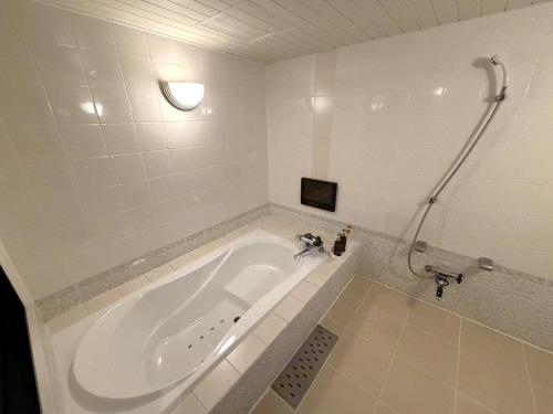 a white bathroom with a tub and a shower at Hotel Orchid (Adult only) in Kurashiki