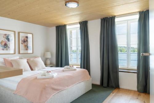 a bedroom with a large bed and windows at Casa Lago in Tüscherz-Alfermée