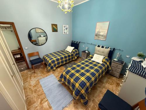 a bedroom with two beds and a mirror at Casa Della Nonna in Radicofani