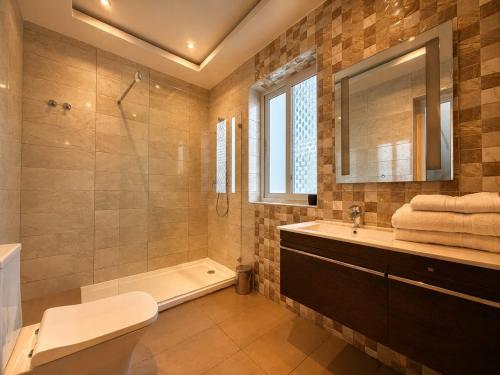 a bathroom with a tub and a toilet and a sink at Spacious Townhouse - Private Jacuzzi -Swieqi in Is-Swieqi