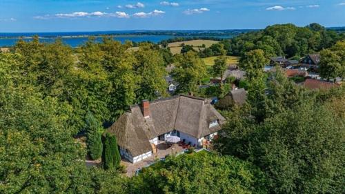 an overhead view of a large house in the trees at Weiße Reetdachkate Wohnung 1 in Stöfs