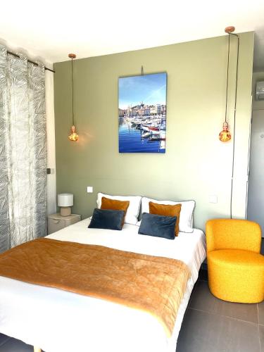 a bedroom with a large bed and a orange chair at Sous le figuier in Marseille
