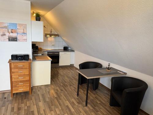 a small kitchen with a table and two chairs at Ostseekoje Koje 5 in Süssau