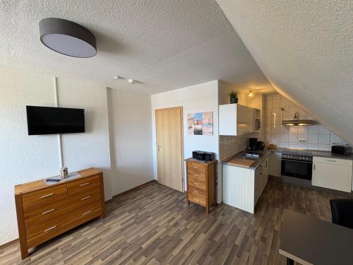 a kitchen with white cabinets and a flat screen tv at Ostseekoje Koje 5 in Süssau