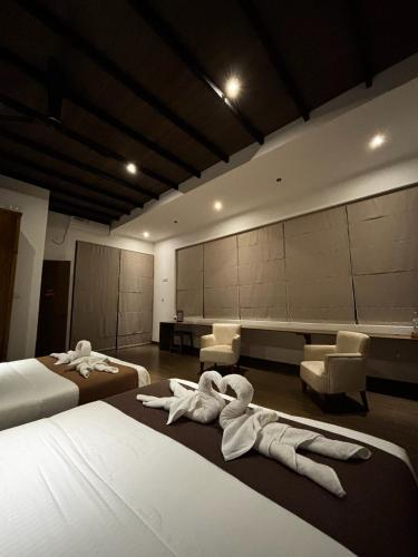 a hotel room with two beds with towels on them at Cinnamon Sunset Villa in Kurunegala