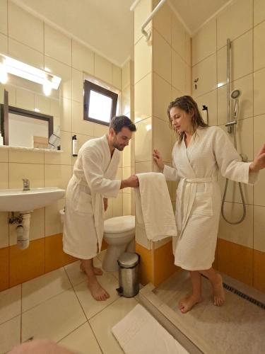 a man and a woman standing in a bathroom at Alma by iVAVev Is'us in Mamaia