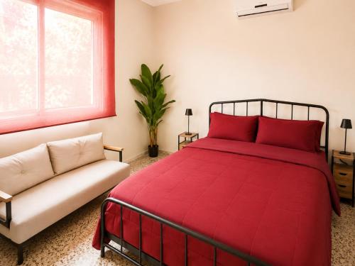 a bedroom with a red bed and a couch at Casa Verna Jacuzzi y Barbacoa in Murcia