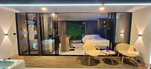 a bedroom with a bed and two chairs and a table at Lake Capsule in Horizonte