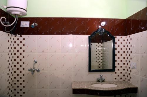 a bathroom with a sink and a mirror at Sajjan Bagh A-Heritage Resort in Pushkar