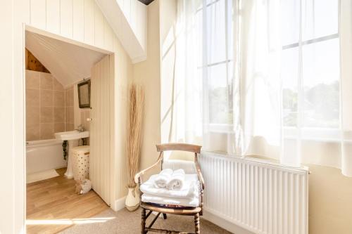 a bathroom with a chair and a tub and a window at 4 Bed in Bridport oc-58847 in Powerstock
