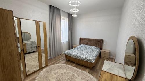 a small bedroom with a bed and a mirror at ReVaN in Baku