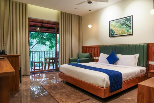 a hotel room with a bed and a balcony at Athirapilly Fernvalley Resort in Athirappilly