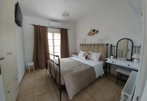a bedroom with a bed with a desk and a mirror at Babis Apartments & Studios Iremia in Acharavi