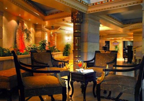a lobby with chairs and a table in a building at Zayed Hotel in Cairo