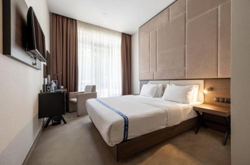 a hotel room with a bed and a desk at Ribas Rooms Odesa in Odesa