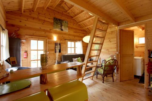 Habitación con cabaña de madera con mesa y sillas en CHALET Meleze Etapeboisee, en Fumay