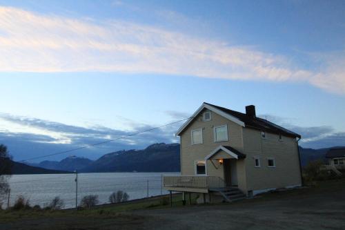 una casa con un porche y un banco en la parte delantera en Slåtteng, en Svensby