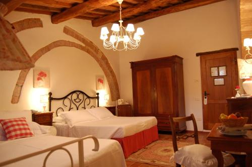 a bedroom with two beds and a chandelier at Hotel Belvedere Di San Leonino in Castellina in Chianti