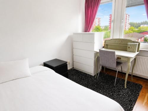 ein Schlafzimmer mit Bett, Schreibtisch und Fenster in der Unterkunft Room in Apartment with Shared Bathroom and Kitchen in Stockholm