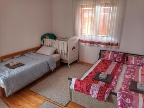 a bedroom with two beds and a crib at Apartment Boka in SJJ