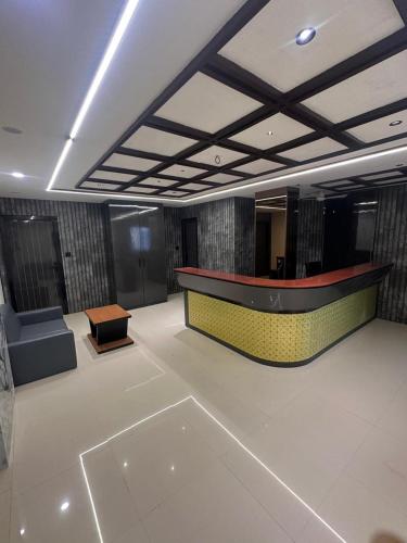 a lobby with a desk and a couch in a room at Hotel Peacock Anand in Anand