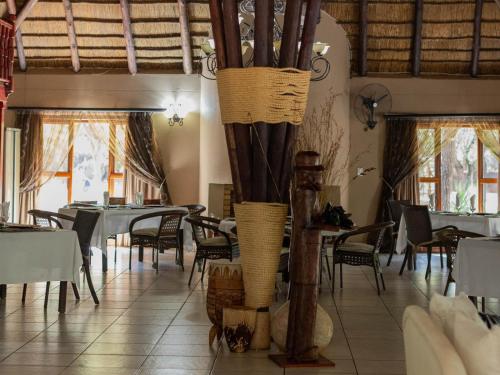 a restaurant with tables and chairs in a room at PHAKELA PRIVATE LODGE in Thabazimbi