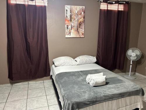 a bedroom with a bed and a fan and curtains at Espacio Hermes Tu Rincón Céntrico in Comayagua