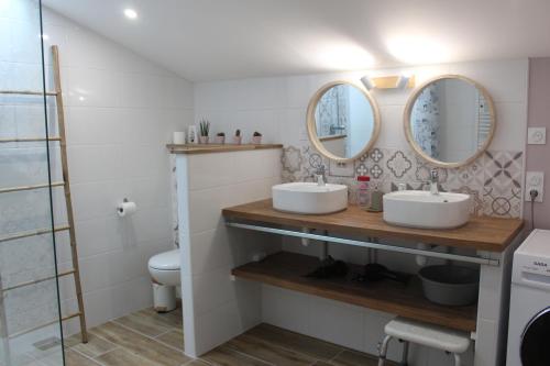 a bathroom with two sinks and two mirrors at GITE familiale avec piscine in Saint-Martin-de-la-Coudre