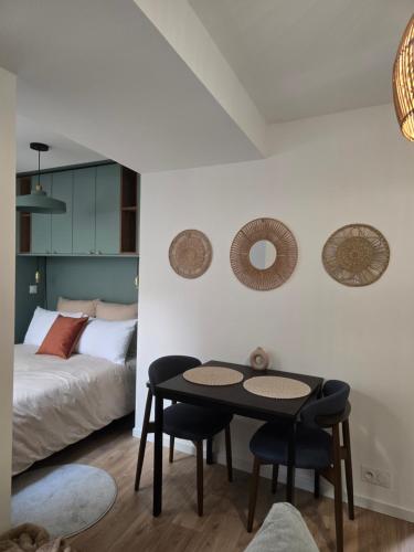 a bedroom with a bed and a table and chairs at Lanabi - Studio Cocon in Salies-de-Béarn