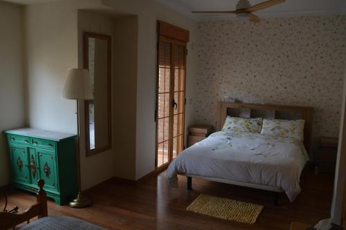 a bedroom with a bed and a mirror and a window at Casa Paola in Buñol