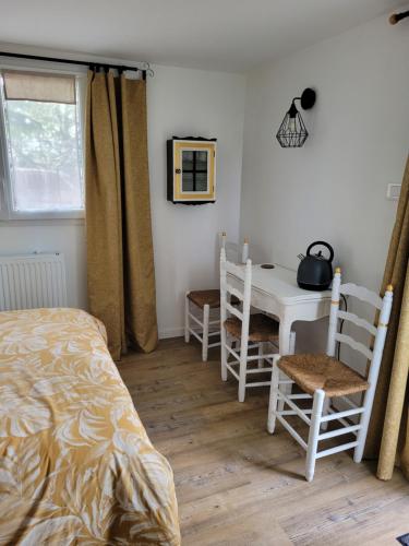 a bedroom with a bed and a table and chairs at chambres d'hôtes BARTAV aile in Espeluche