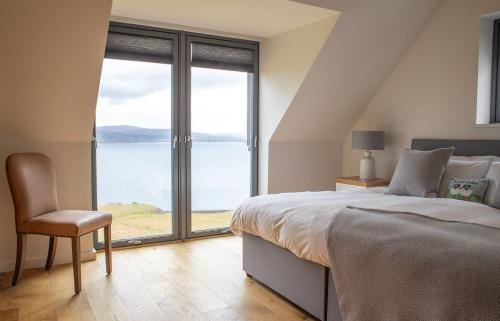 a bedroom with a bed and a view of the water at Cnoc Na Lobhta in Husabost