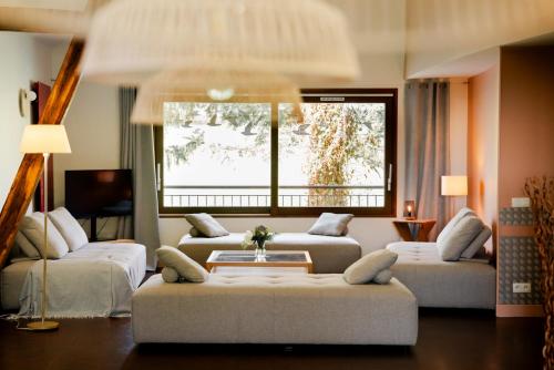 a living room with two couches and a large window at Gîte Le Cot en Vallée d'Ossau in Sainte-Colome