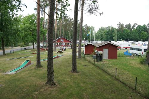 a park with a playground with trees and buildings at Bromölla Camping o Vandrarhem in Bromölla
