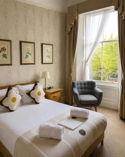 a bedroom with a bed and a chair and a window at Gladstone House in Edinburgh