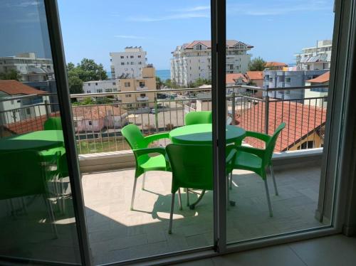 a view of a balcony with green tables and chairs at Katalea Apartment in Shëngjin